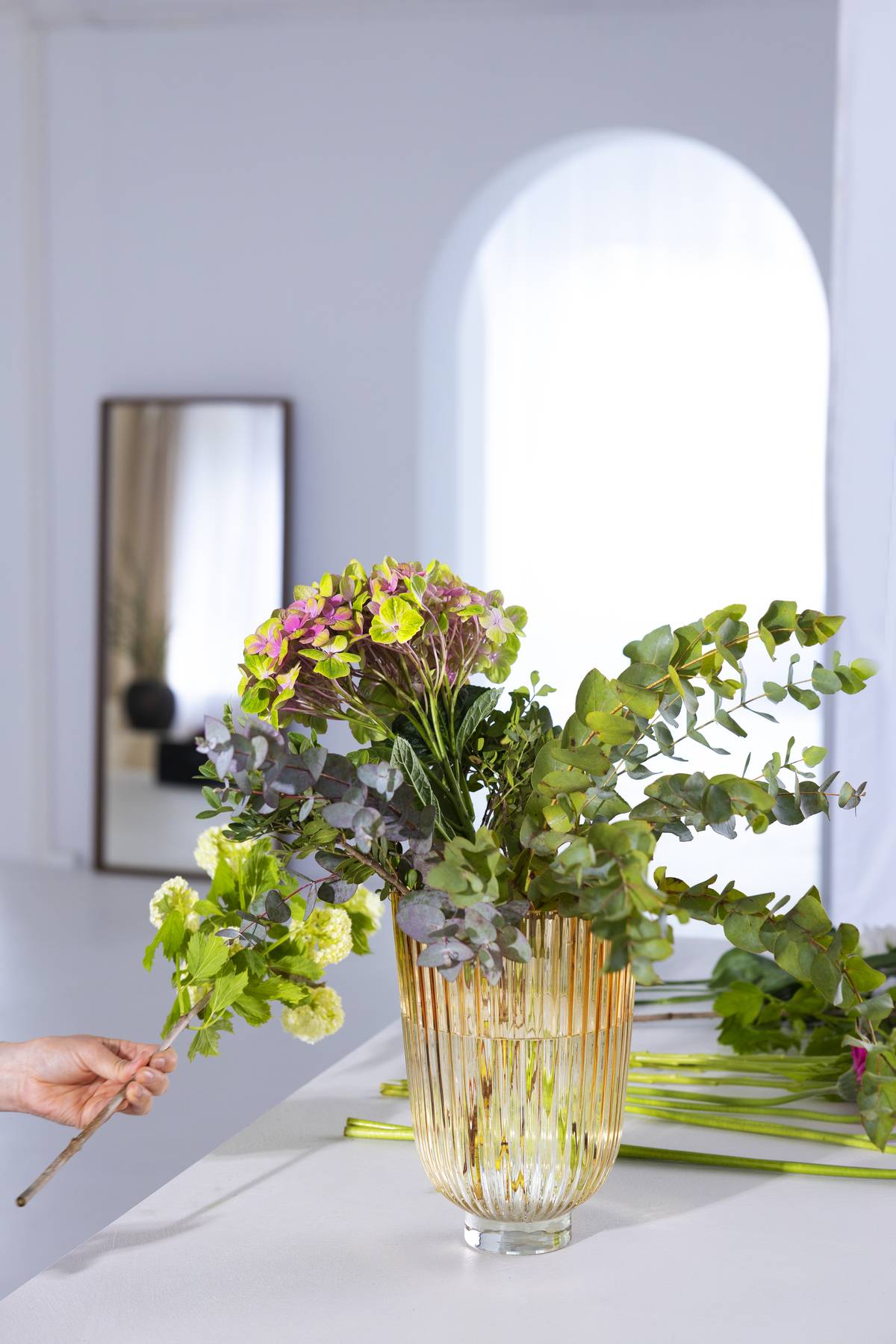 Glazen vaas met groot boeket met paars, roze en groene bloemen