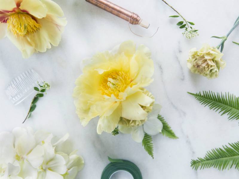 Bloemaccessoire van pioenroos, orchidee en varenblaadjes