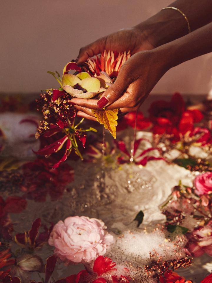 Kleurrijke bloemen, waaronder oranje, rode en roze, drijvend in een schuimige vloeistof