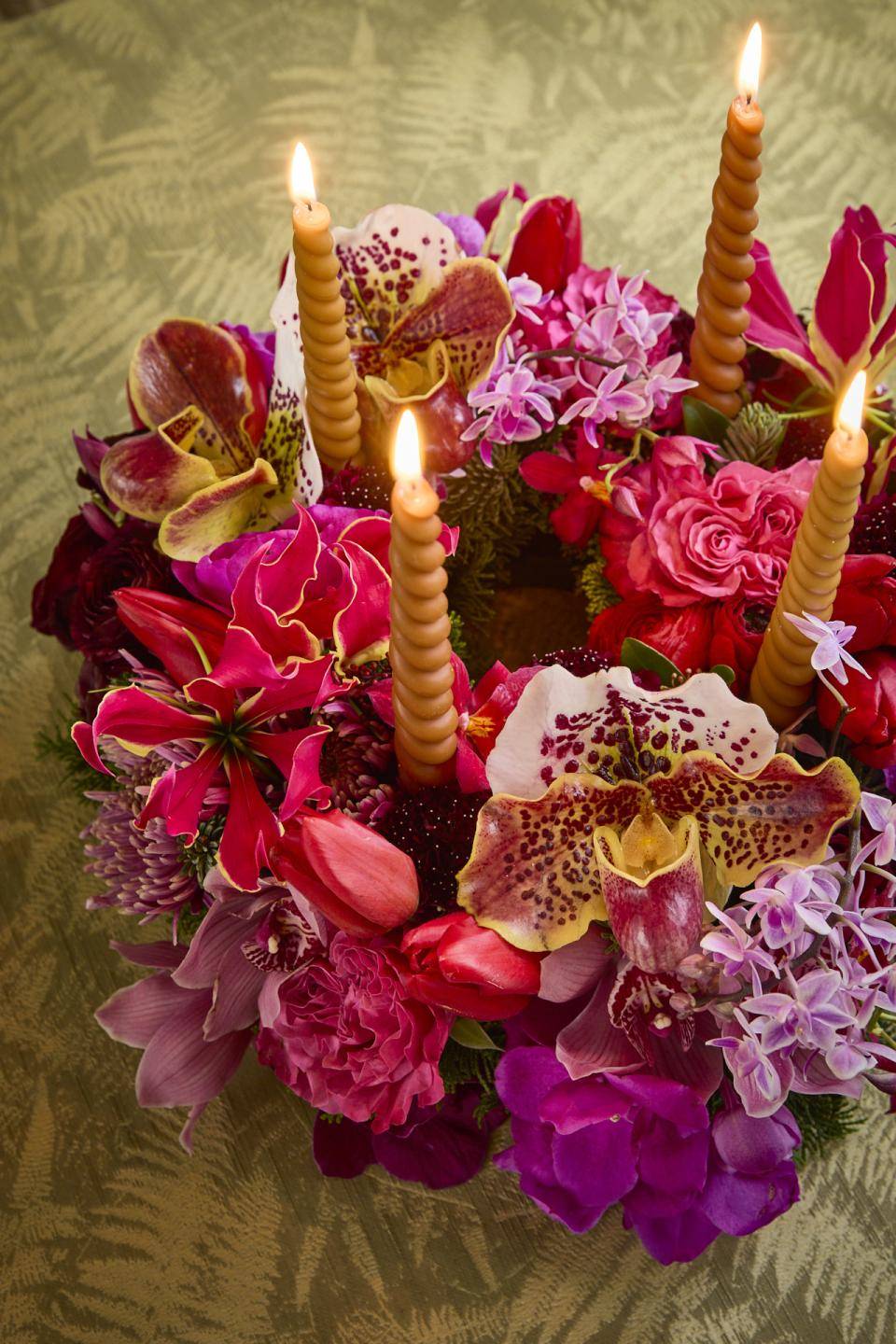 Kerstkrans met kaarsen en winterbloemen