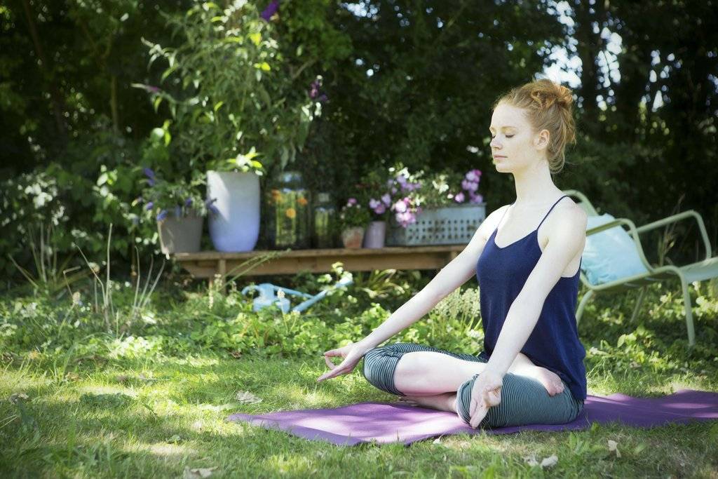 Yoga in groene tuin met bloeiende planten