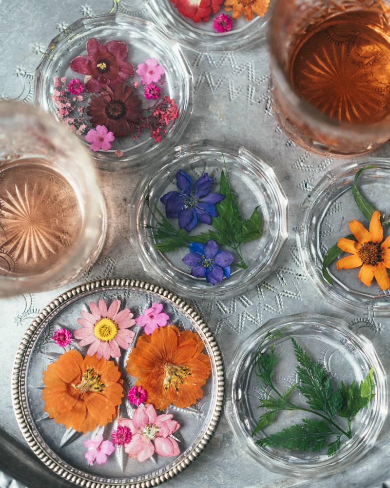 Glazen onderzetters met gedroogde bloemen en blaadjes