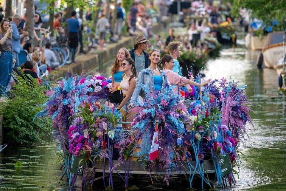 Varend corso bloemenmeisjes met blauw paarse bloemen